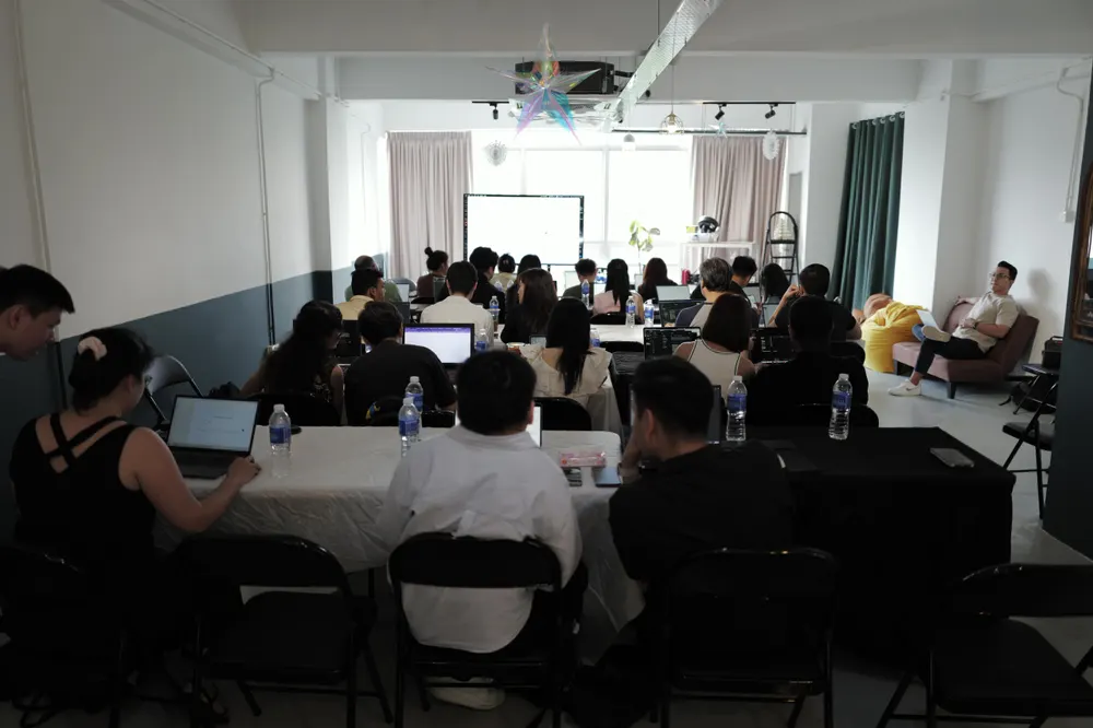 Wide shot of the full workshop room at working pace